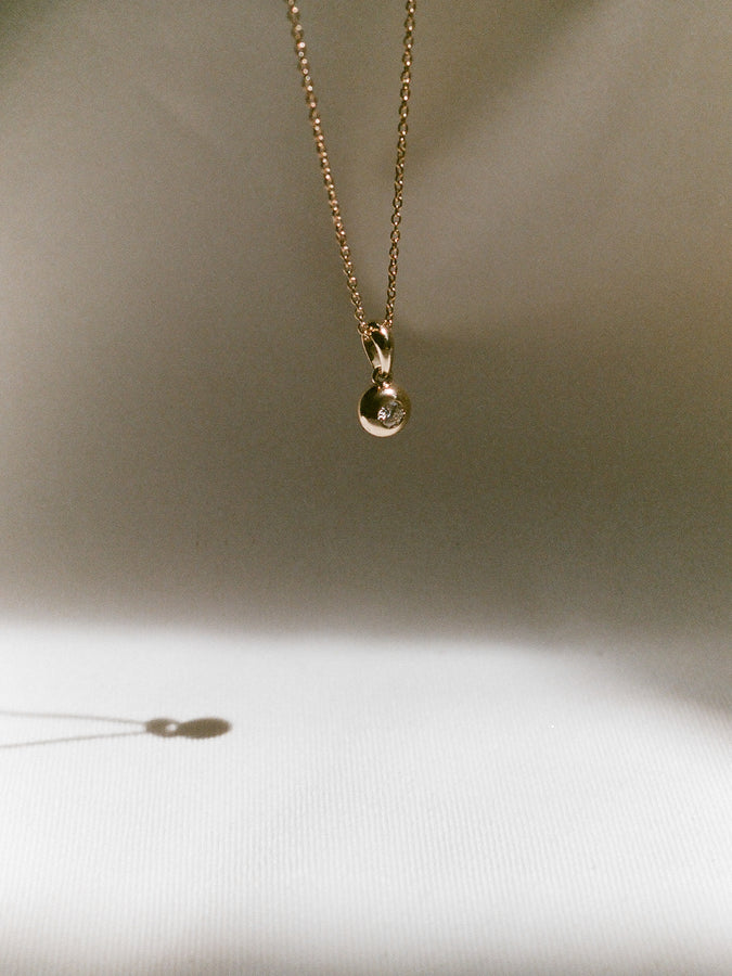 J. Hannah Diamond Form Pendant necklace in 14k gold in sun.