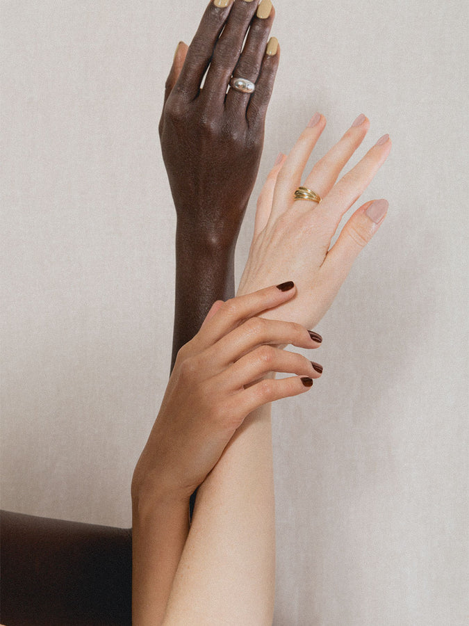 Three hands wearing J. Hannah Carob Nail Polish.