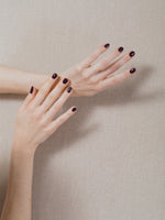 Hands wearing J. Hannah Carob Nail Polish.